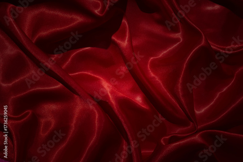 Top view  shiny red silk fabric with smooth, flowing folds and light reflections.