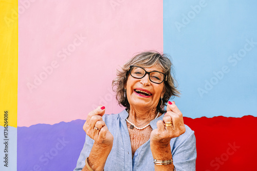 Wallpaper Mural Senior woman expressing joy, laughing at colorful background Torontodigital.ca