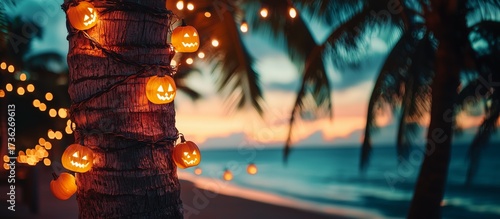 Pumpkin Halloween garlands on a palm tree at sunset on the beach.Glowing pumpkin Halloween garlands wrapped around a palm tree on a tropical beach at sunset. copy space