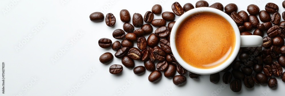 Fototapeta premium A steaming cup of coffee surrounded by roasted coffee beans on a white surface, highlighting a rich brown beverage.