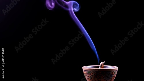 Colorful incense smoke rising from decorative holder on black background  