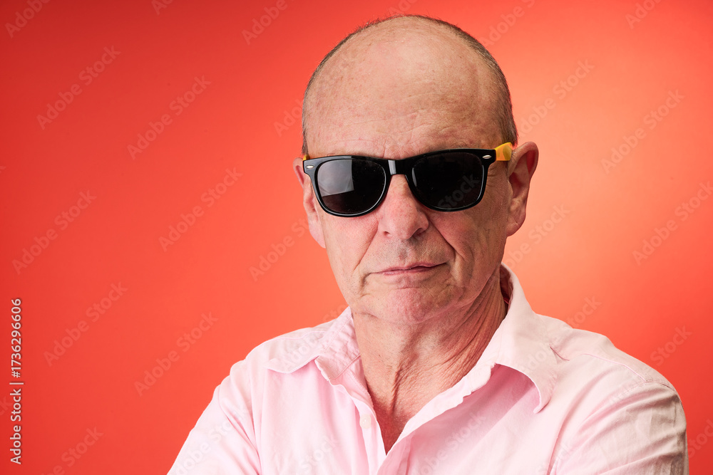 Obraz premium Closeup portrait of a elderly man in studio wearing sunglasses