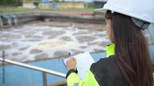 Engineer inspecting wastewater treatment plant and recording data for environmental monitoring. Concept of water management, industrial inspection, and sustainability process.