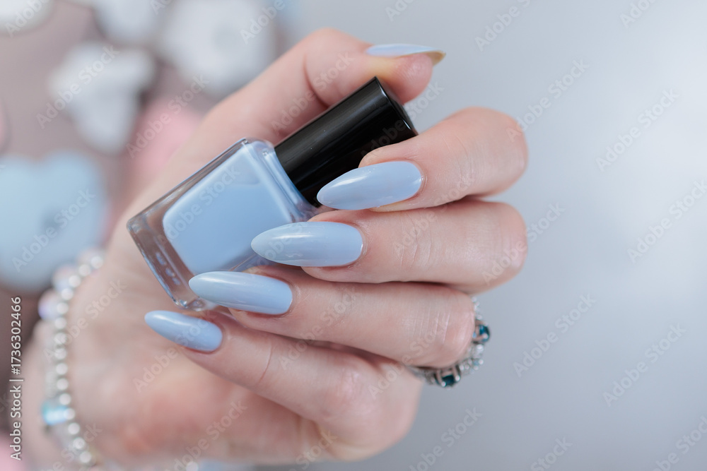 Fototapeta premium beautiful hand with long nails and light baby blue manicure