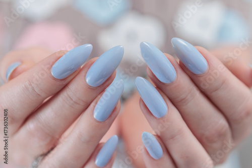 Woman's beautiful hand with long nails and light baby blue manicure	