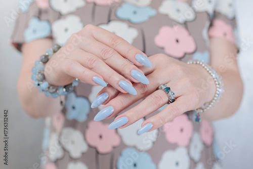Woman's beautiful hand with long nails and baby blue manicure