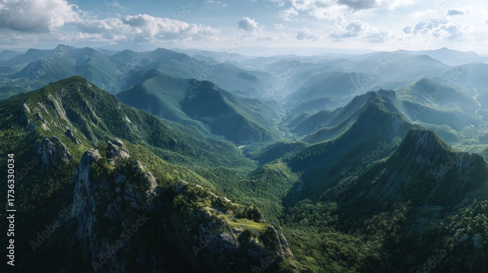 Obraz premium The green mountains stretch with green slopes rolling into the distance, where green valleys lie under a blue sky. Sunlight touches green peaks, and green shadows fall across ridge