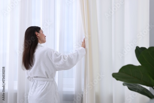 Woman opening stylish window curtains at home Free Download Woman opening stylish window curtains at home - GFXLoad