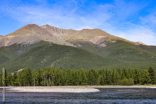 Summer adventure view of rugged mountains, tundra slopes, and powerful mountain river
