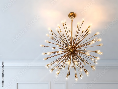 Retro starburst warm gold lighting fixture against a white wall.