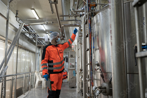 Male engineer working in canned fish factory checking autoclave sterilizer machine, temperature control valve. Canned fish factory, seafood manufacturing and processing