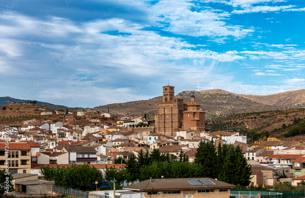 Obraz premium The historic village of Aniñón, crowned by its magnificent Mudejar church, nestled in the rolling hills of Aragon, Spain.