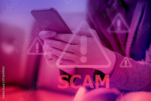 Hand using smartphone with scammer alert; Cyber security concept