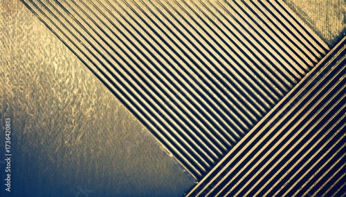 abstract metallic gold and blue striped texture with vertical lines and soft gradient light reflections creating a modern geometric background ideal for wallpaper banner or commercial design