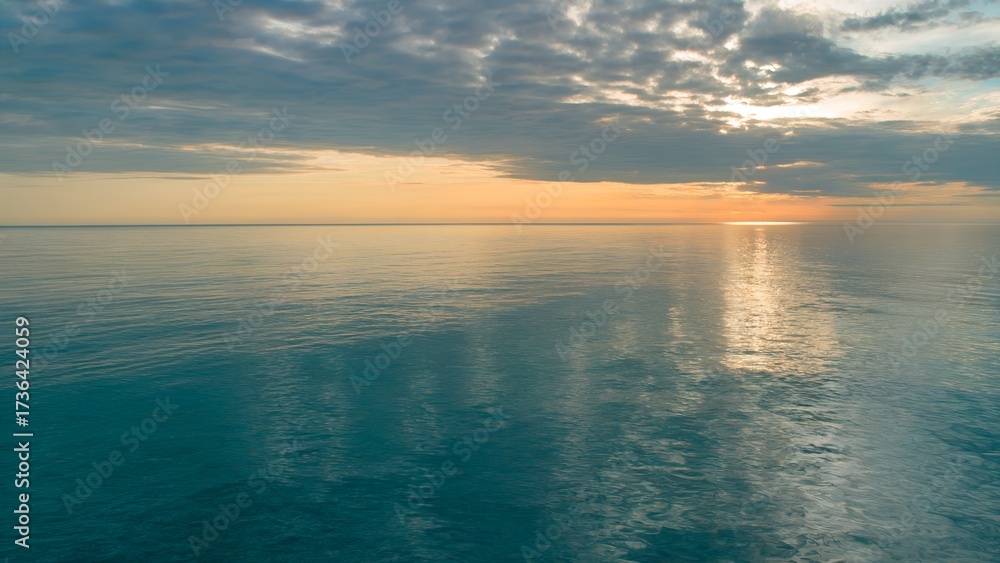 Obraz premium Ocean Sunset with Reflective Water and Cloudy Sky horizon.