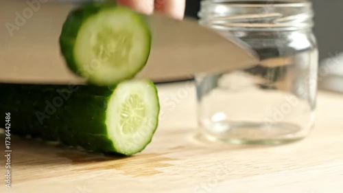 Slicing Fresh Cucumber: Preparing Healthy Pickles in a Glass Jar