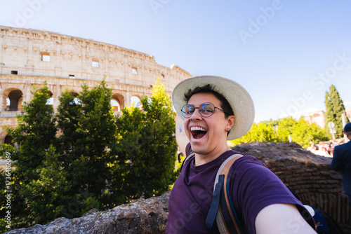 Photography Cheerful male tourist taking a selfie in front of the colosseum in rome, italy
