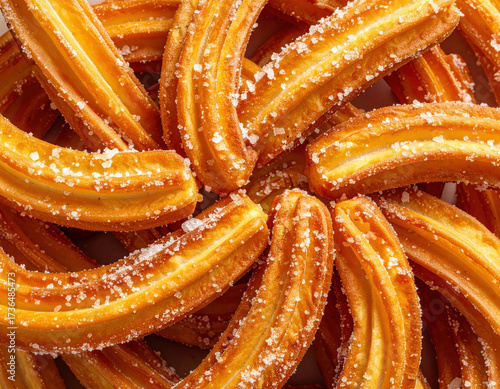 Crispy churro sugar crystal golden pastry fried dessert sweet snack cinnamon sugar closeup texture confection indulgent treat Swirls of crispy churro coated with sugar crystal, golden pastry with