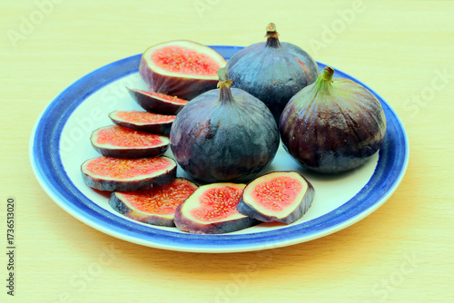 A plate containing whole and sliced fresh figs.