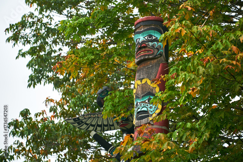 Stanley Park Totem in Autumn Trees. Stanley Park totem pole surrounded with autumn leaves, Vancouver, British Columbia, Canada.
