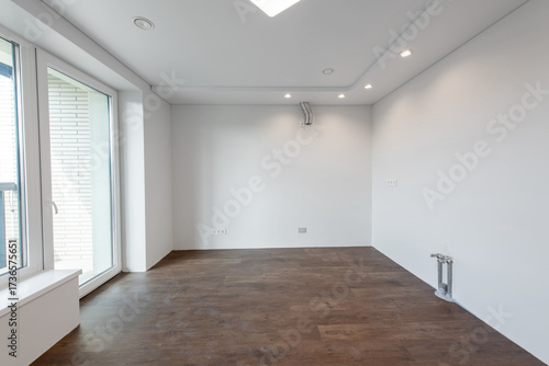Empty Home Kitchen Interior. White Walls Room Corner and Windows. Interior Empty Room with White Walls and Wooden Floor.