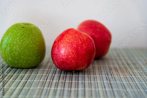 Fresh red and green apples placed on a wooden table, showcasing natural colors and textures. A healthy and simple scene perfect for themes of nutrition, fresh fruit, organic lifestyle, healthy eating,