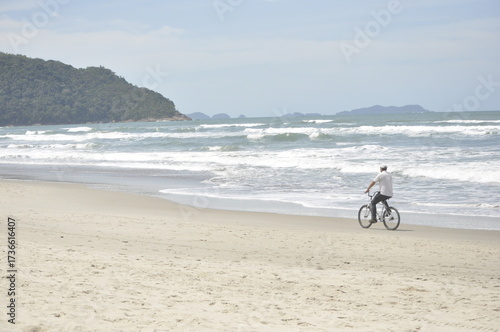 man on a bicycle in the beach at morning
