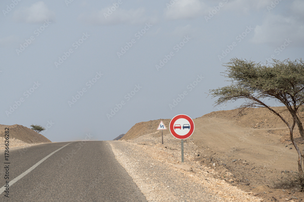 Ταπετσαρία Signs on one of Morocco's roads indicating that it is forbidden to overtake on this stretch and another warning of the proximity of dangerous curves