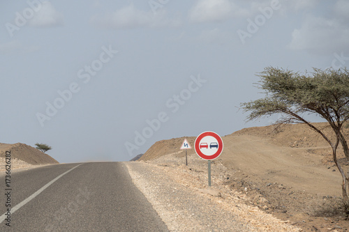 Fotografija Signs on one of Morocco's roads indicating that it is forbidden to overtake on this stretch and another warning of the proximity of dangerous curves