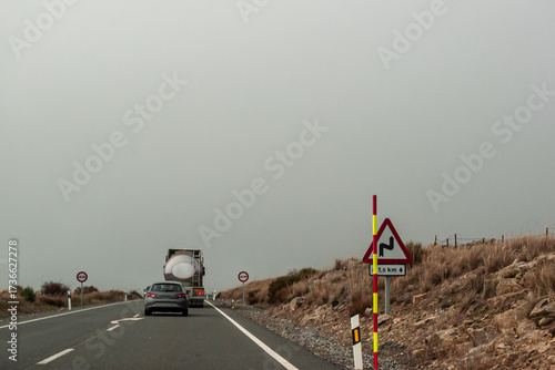 Canvas Print A car behind a truck will have to wait behind it, because it encounters a vertical no overtaking sign