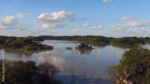 aerial view of lake in Africa, with blue water and lush vegetation, dam at low altitude, pristine ecosystem, tourist destination