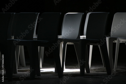 Tableau sur toile chaises en plastique vides, effet d'ombre et de lumière sur des sièges