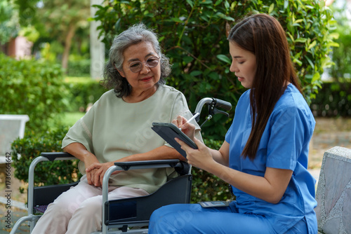 Caregiver provides assistance and support to senior in wheelchair, ensuring they receive necessary care and attention in serene outdoor setting