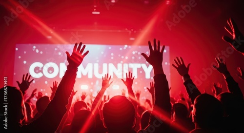 Wallpaper Mural A crowd of people with their hands raised in the air at a concert or event, illuminated by red stage lights with the word community displayed on a screen behind them Torontodigital.ca