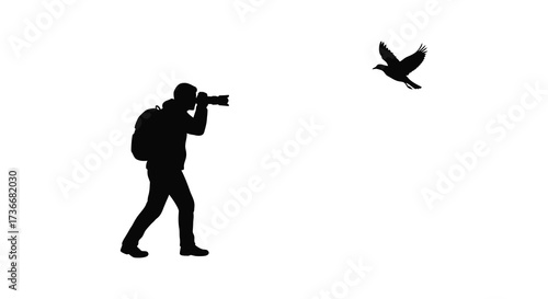 Silhouette of photographer capturing a flying bird in flight with camera and backpack