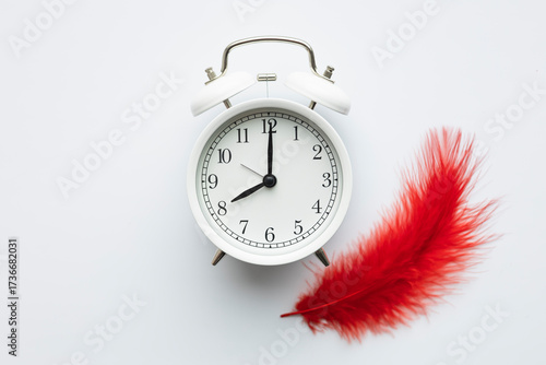Clock and red feather illustrating menstruation concept