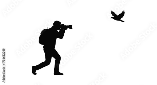 Silhouette of a photographer capturing a bird in flight outdoors