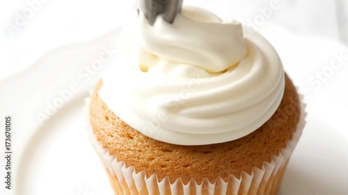 Expertly Piping Sweet Buttercream Frosting onto a Freshly Baked Golden Vanilla Cupcake