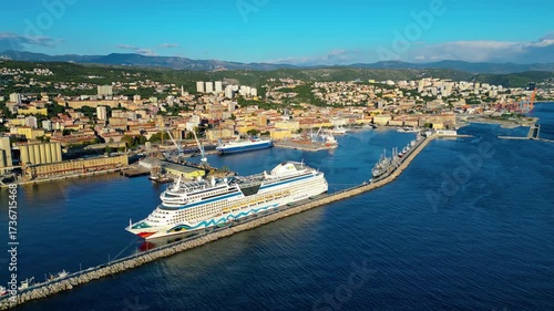 AIDAblu cruise ship docked in the port of Rijeka, Croatia, captured from a drone with the city and mountains in the background on a sunny day