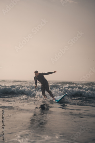 Photography Surfing scene at sunset, man surfing with a foam surf board