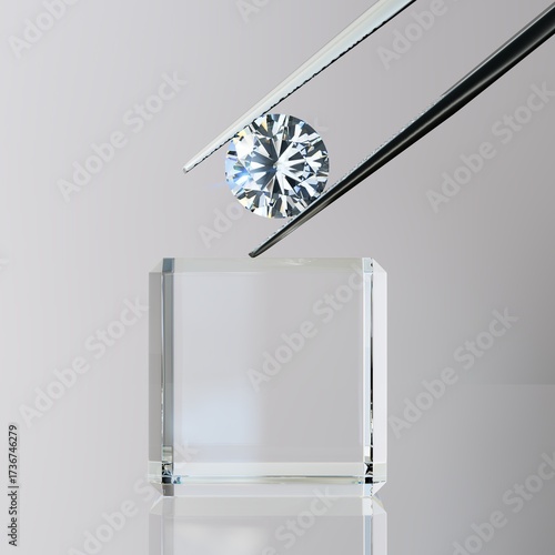 Round brilliant cut diamond in tweezers on crystal cube on gray background