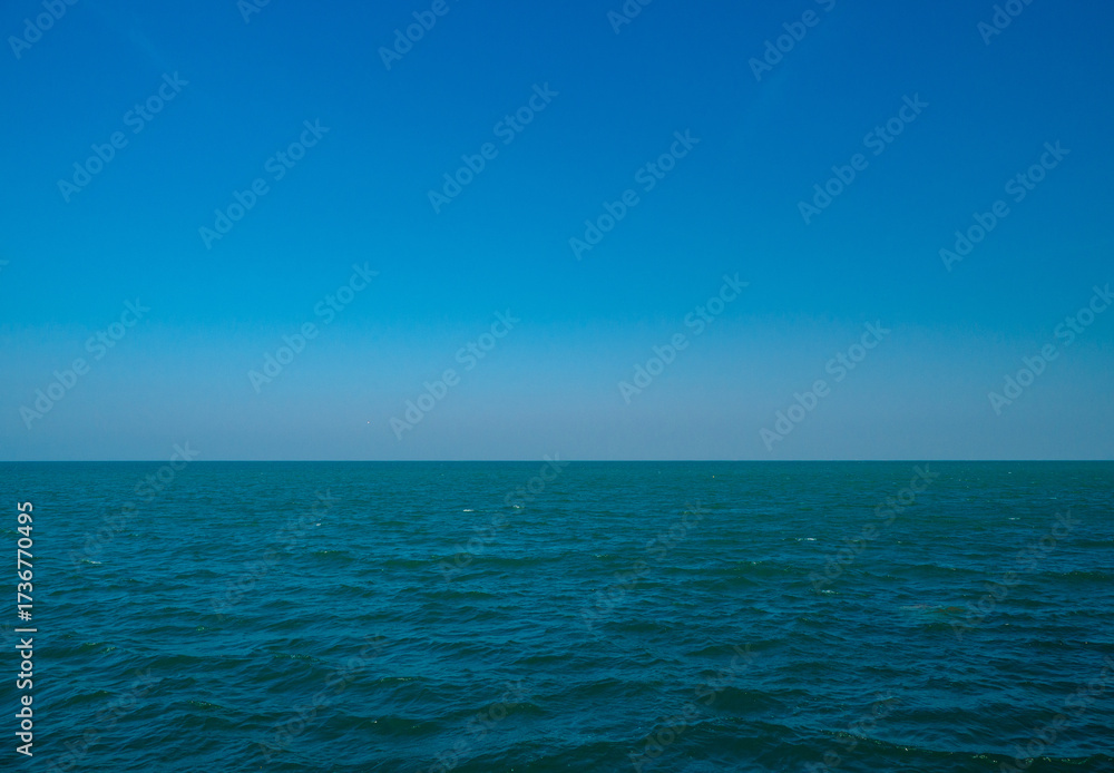 Fototapeta premium Photography tranquil seascape with calm sea ocean waters stretching to the horizon under a clear blue sky, evoking peace and openness.relaxing summer scene perfect for travel holliday and nature lover
