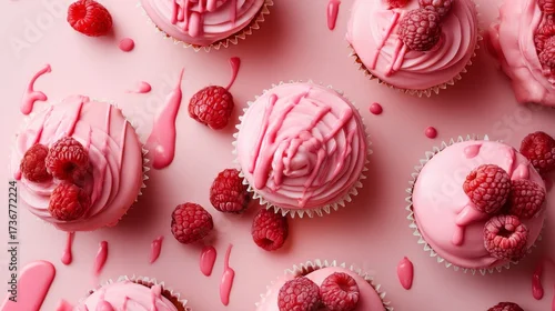 Obraz  z motywem Variety of pink cupcakes decorated with raspberry toppings on a light pink background