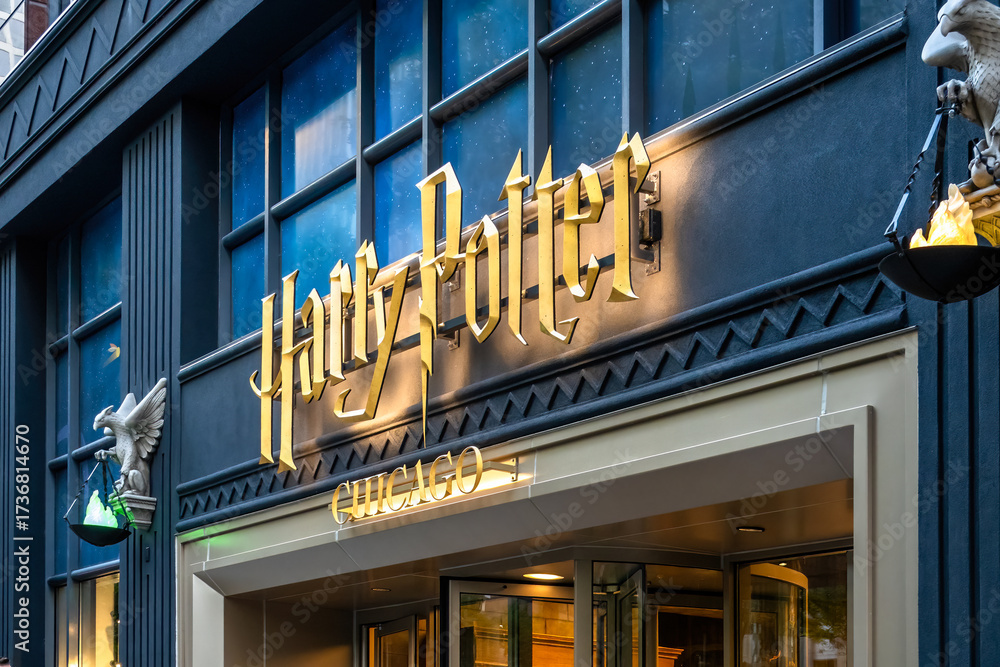 Fototapeta premium Chicago, Illinois, USA. Oct 2, 2025. Close-up of a Harry Potter Store entrance featuring a large, ornate golden sign above a doorway, flanked by bird-like sculptures with glowing bowls.
