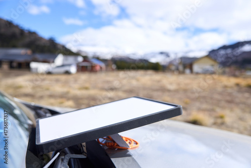 Satellite internet receiver antenna on the front of a car to get a signal and connect to the network in a remote village. Current technology allows to stay connected while traveling.