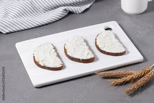 Sandwiches with cream cheese on a white cutting board