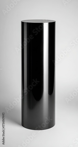 Glossy black cylinder pedestal on light gray background