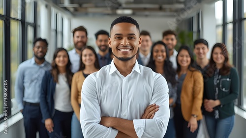 Smiling millennial student looking at camera posing for portrait in front of diverse young people group getting education at international university, happy ambitious intern receiving job at company