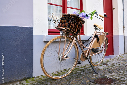 Bike with Basket Parked in Europe. A bicycle parked on a cobblestone street in front of a home in an old town in Europe.
