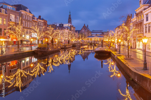 Holiday Christmas illumination along canal in historic center of Leiden, Netherlands